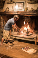 Un homme attise un feu de chemin&eacute;e