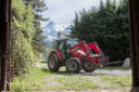 Tracteur par la porte d'un hangar en montagne