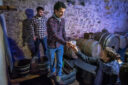 Un homme sert du jus de pomme issu d'un pressoir traditionnel